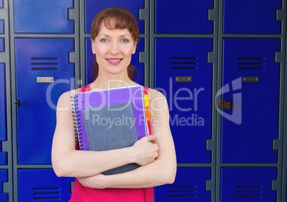 female student holding folders in front of lockers