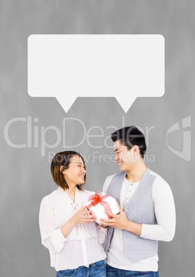 Couple with speech bubble smiling against grey background