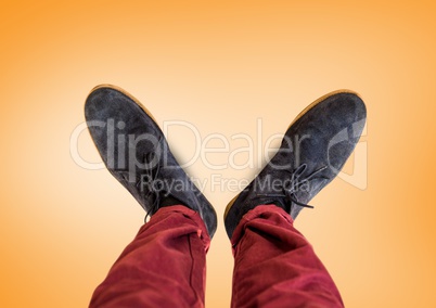 Grey shoes on feet with orange background