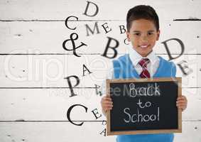Many letters around Schoolboy holding blackboard with Back to school text