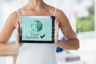 Woman holding a tablet with travel insurance concept on screen