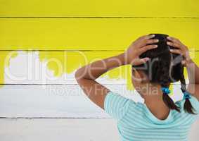 Girl looking at painted yellow wall