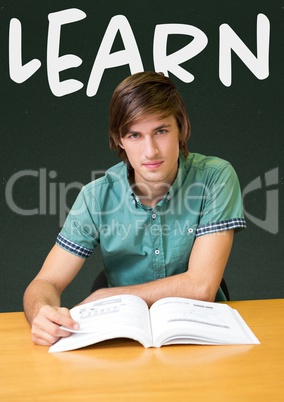 Student boy at table against green blackboard with learn text