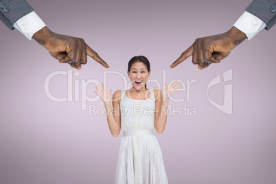Hands pointing at surprised business woman against pink background