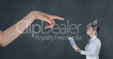 Hand pointing at business woman holding a tablet against blue background