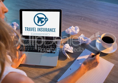 Woman using a computer with travel insurance concept on screen