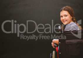 Disabled girl in wheelchair in front of blackboard