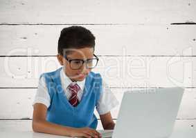 Schoolboy on laptop with wood background