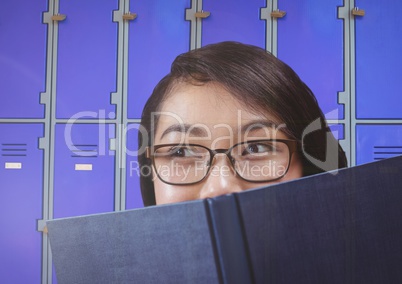 female student holding book in front of lockers