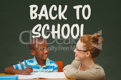 Student boy and teacher at table against green blackboard with back to school text