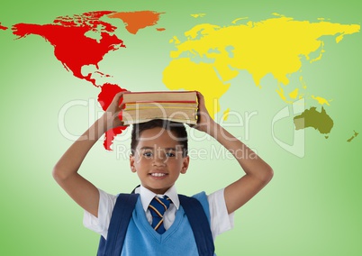 Schoolboy holding books on head in front of colorful world map