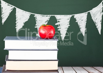 Books on the table against green blackboard with graphics