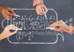 Hands writing equations on blackboard