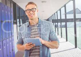 male student holding tablet in front of lockers