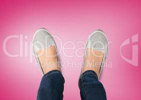 Grey shoes on feet with pink background