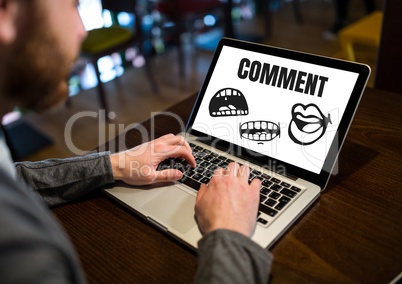Comment text and cartoon mouth graphic on laptop screen with mans hands