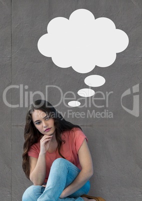 Young woman with speech bubble sitting against grey background