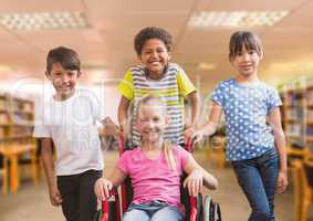 Disabled girl in wheelchair with friends in school library