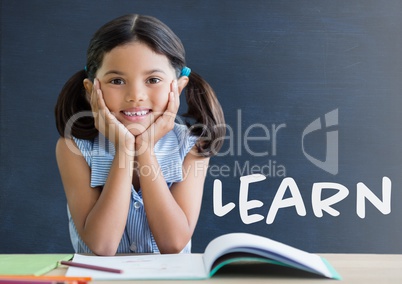 Student girl at table against blue blackboard with learn text