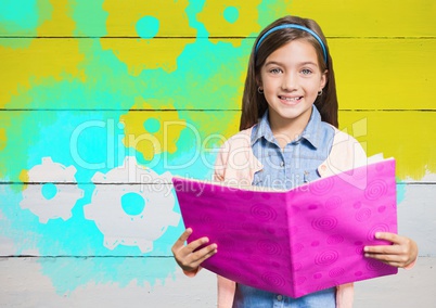 Girl holding book in front of yellow painted wall with cog gear settings