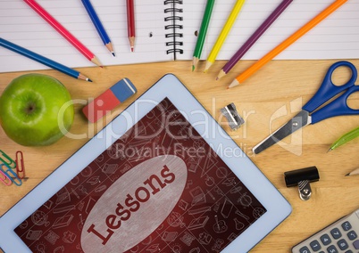 Tablet on a school table with school icons on screen