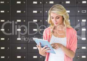 female student holding tablet in front of lockers