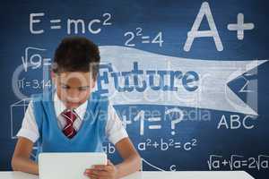 Student boy at table using a tablet against blue blackboard with future text
