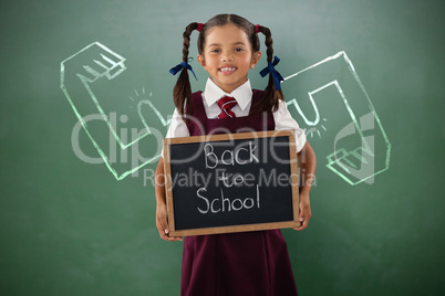 Composite image of smiling schoolgirl holding writing slate