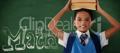 Composite image of smiling schoolboy carrying books on head over white background