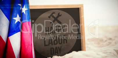 Composite image of happy labor day text with tools on red poster