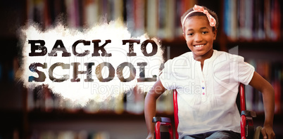 Composite image of girl sitting in wheelchair in school corridor