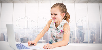 Composite image of girl using laptop at table