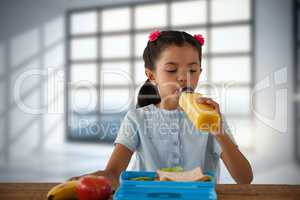Composite image of girl drinking juice at table