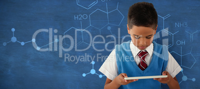 Composite image of schoolboy using digital tablet