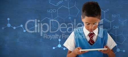 Composite image of schoolboy using digital tablet