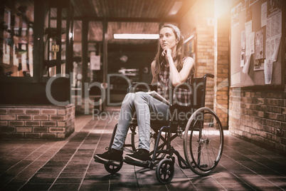 Disabled schoolgirl on wheelchair in corridor at school