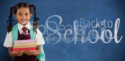 Composite image of smiling schoolgirl carrying books