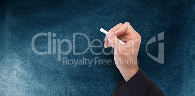 Composite image of hand holding a chalk and writing something