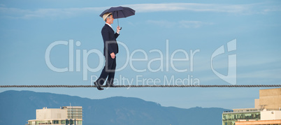 Composite image of businessman with umbrella walking on white background