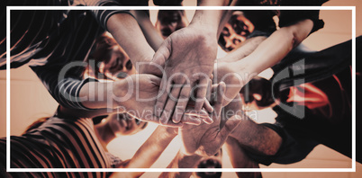 Creative business team stacking hands together