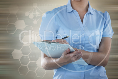 Composite image of beautiful businesswoman writing on clipboard