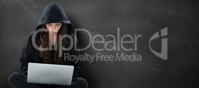 Composite image of young female hacker using laptop while sitting