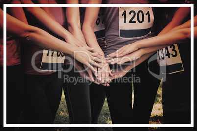 Female breast cancer marathon runners stacking hands