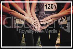 Female breast cancer marathon runners stacking hands