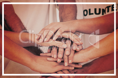 Mid section of volunteers stacking hands