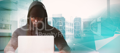 Composite image of serious male hacker with laptop
