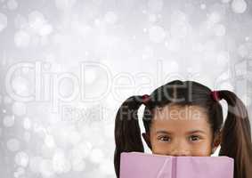 Girl reading in front of bright bokeh background