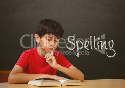 Student boy at table against grey blackboard with spelling text