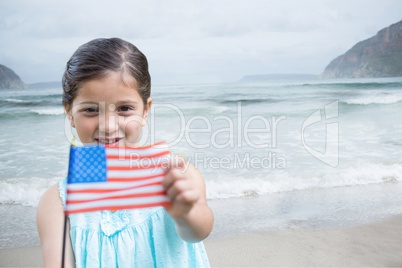 Girl holding a USA flag in the beach