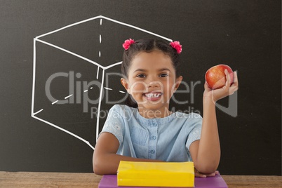 Happy student girl at table holding an apple against grey blackboard with school and education graph